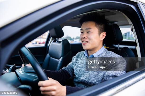 young man driving car - asian man car stock pictures, royalty-free photos & images