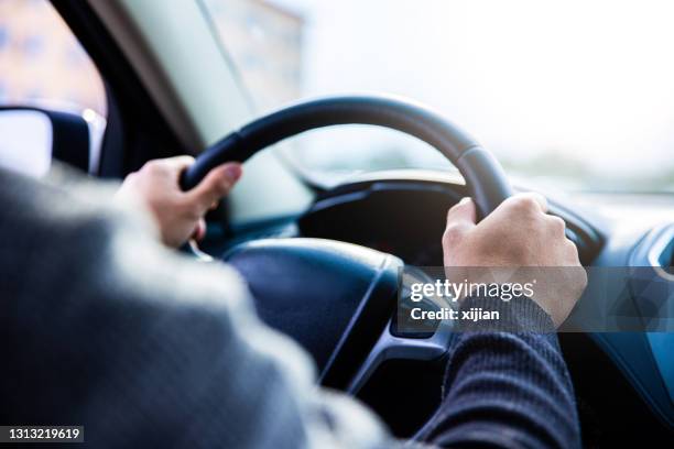 close-up young man driving car - steering wheel stock pictures, royalty-free photos & images
