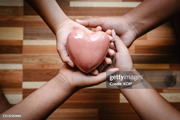 high angle view of human hands holding heart shape together. medical and healthcare insurance concepts - build presents sensitive skin stock pictures, royalty-free photos & images