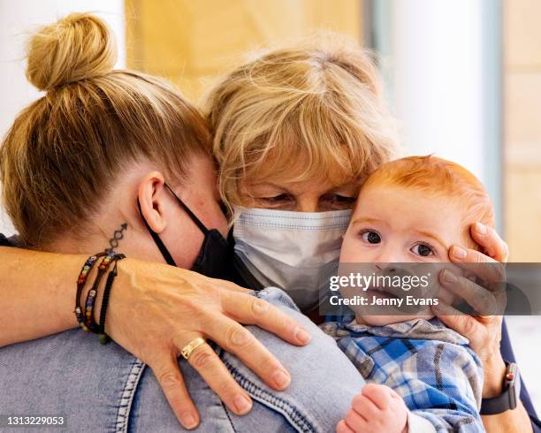 Dianne Wright hugs daughter Tania Wright and baby Mason Buckley at Sydney International Airport on April 19, 2021 in Sydney, Australia. The...