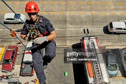 Late 30s Male Firefighter Practicing Escape System By Rope High-Res ...