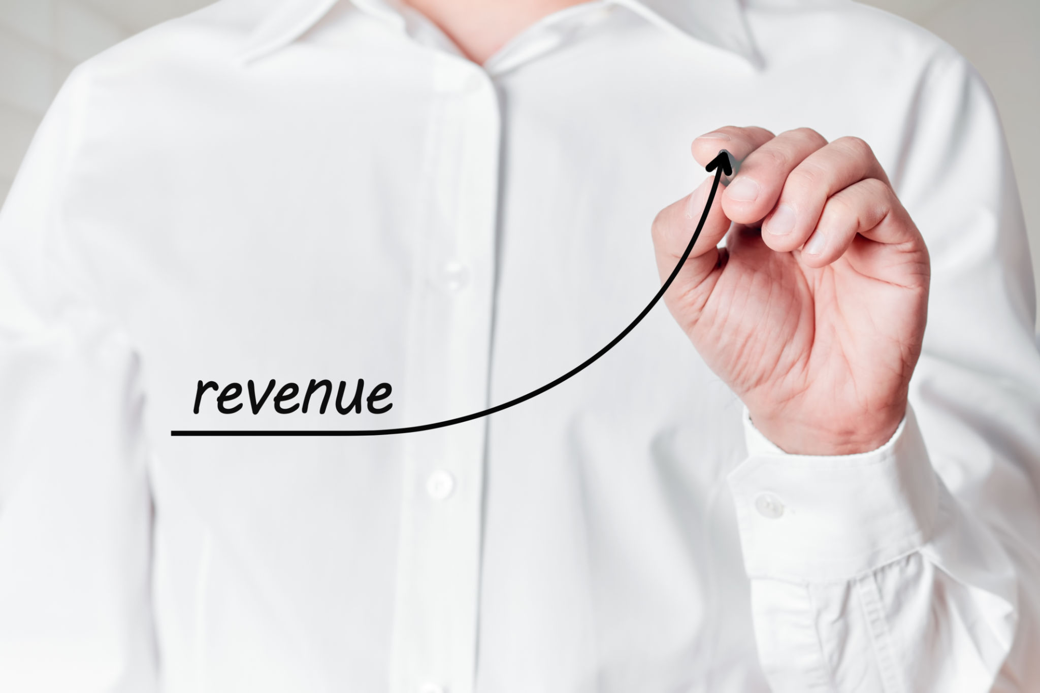 Businessman with a pen draws a rising line graph with the word revenue on a virtual screen. Business revenue increase Businessman with a pen draws a rising line graph with the word revenue on a virtual screen. Business revenue increase