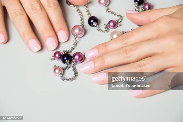 pair of elegant hands with pink nail paint - fashion glamour pearl stock pictures, royalty-free photos & images