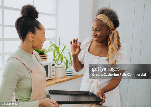 cooking lesson - woman explaining a cooking method to a student - mother daughter baking stock pictures, royalty-free photos & images
