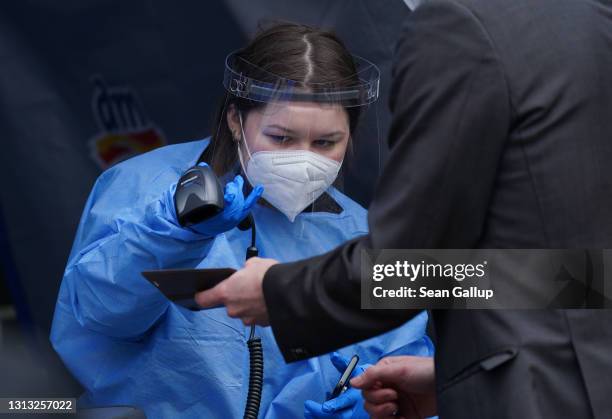 Medical worker scans the QR code of a man arriving for a Covid test at a Covid testing station operated by German drugstore chain DM at a press event...
