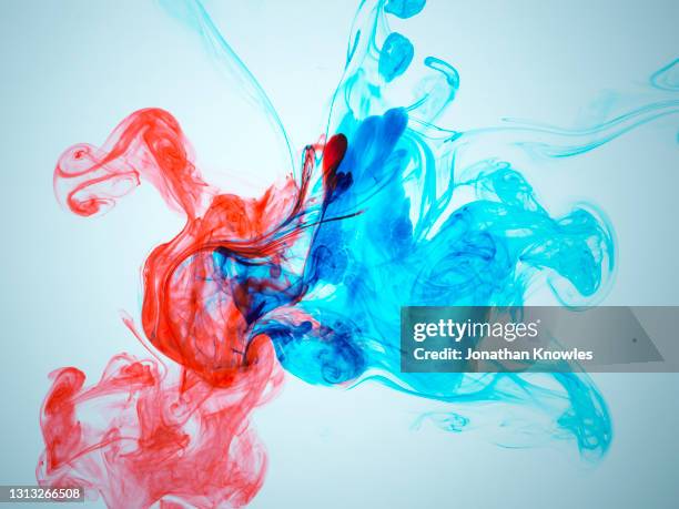 blue and red ink in water - folding stockfoto's en -beelden