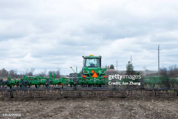 terreni agricoli in canada - trattore con erpice a disco in campo ad aprile - disc plough foto e immagini stock