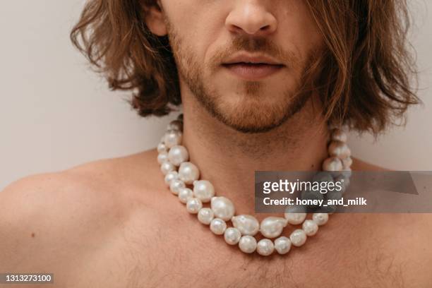 portrait of a handsome shirtless man wearing pearl necklaces - pearl necklace stockfoto's en -beelden