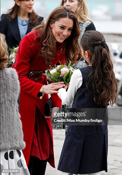 Catherine, Duchess of Cambridge receives a posy of flowers as she arrives for a visit to the UNICEF emergency supply centre on November 2, 2011 in...