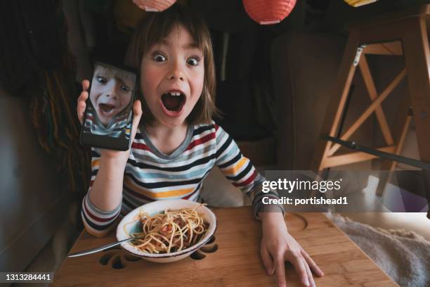 gelukkig kind dat spaghetti eet en selfie neemt bij in een self made huistent - hiding from selfie stockfoto's en -beelden