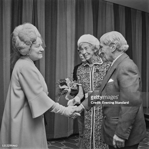 Queen Elizabeth the Queen Mother meets German-born philanthropist Sir Robert Mayer and his wife, Lady Dorothy Moulton Mayer, at the Robert Mayer...