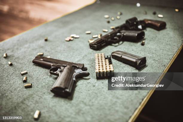 moderne pistolen und pistolenpatronen im gun training range - pistolen kugeln stock-fotos und bilder