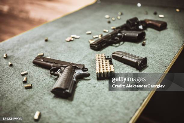 pistolas modernas e cartuchos de armas no campo de treinamento de armas - pistola - fotografias e filmes do acervo