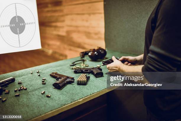 male checking firearm safety before proceeding with training on gun range - gun safety stock pictures, royalty-free photos & images