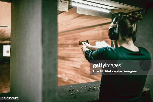 moderne männchen konzentriert auf gun training auf reichweite - sportschießen stock-fotos und bilder
