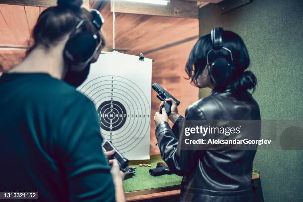 kvinna förklarar triggerkontroll till man under grundläggande vapenutbildning - arsenal women training session bildbanksfoton och bilder