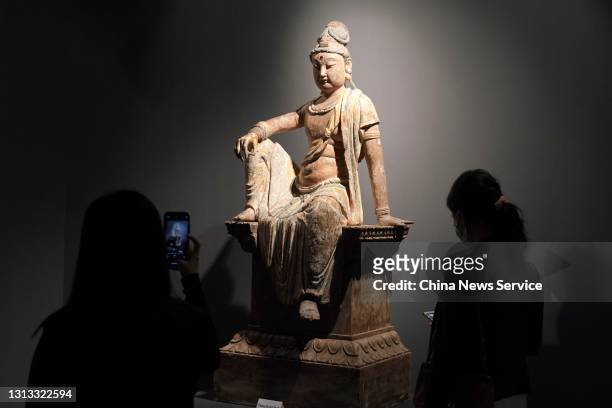 Visitor takes photos of a sculpture depicting Guanyin, the Goddess of Mercy, during Sotheby's Hong Kong Spring Sales at the Hong Kong Convention and...