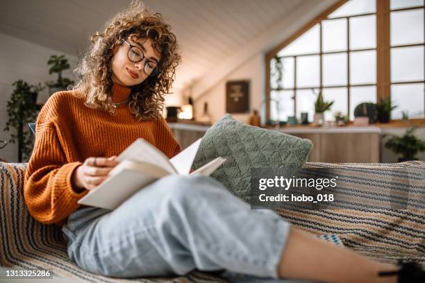 enjoys morning in living room - woman reading book stock pictures, royalty-free photos & images