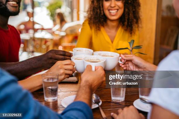 friends toasting coffee drink at coffee shop - friends toasting above table stock pictures, royalty-free photos & images