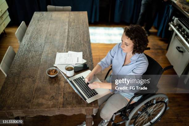 disability woman using laptop working at home - amputee home stock pictures, royalty-free photos & images