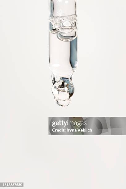 beauty product with transparent yellow liquid and shadow from nature leaves on beige background with oil drops. - blood serum stock pictures, royalty-free photos & images