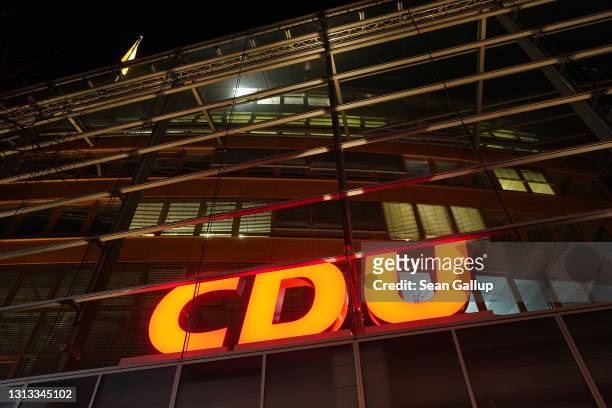 The logo of the German Christian Democrats hangs illuminated at the CDU party headquarters where inside the party leadership and CDU leader Armin...