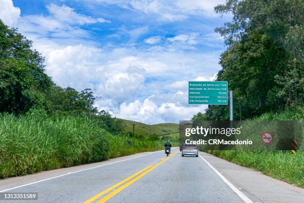 the transit on the oswaldo cruz highway in the middle of nature and under blue sky between clouds. - ubatuba stock pictures, royalty-free photos & images