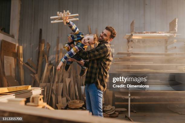 father and son playing with a toy wooden plane - fathers day tools stock pictures, royalty-free photos & images