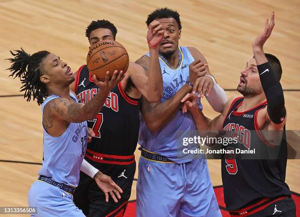 Ja Morant of the Memphis Grizzlies puts up a shot between Troy Brown Jr. #7 and Nikola Vucevic of the Chicago Bulls and teammate Xavier Tillman at...