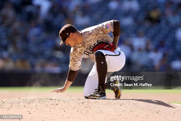 Keone Kela of the San Diego Padres wipes the mounds prior to pitching during a game against the Los Angeles Dodgers at PETCO Park on April 18, 2021...