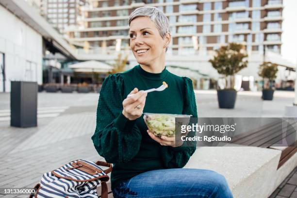 portret van een gelukkige vrouw op een lunchonderbreking - eating salad stockfoto's en -beelden