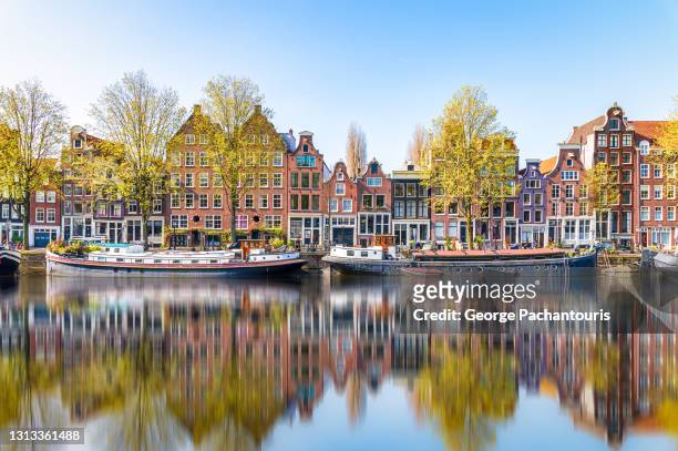 reflections in the morning on a canal of amsterdam, holland - netherlands stock-fotos und bilder