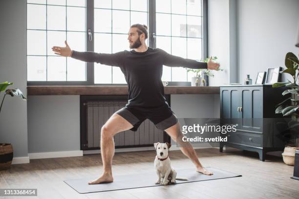 在家練習瑜伽的年輕人 - 訓練犬 個照片及圖片檔