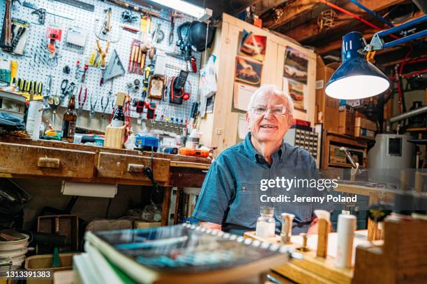 portret van een gelukkige hogere kaukasische mensenzitting in zijn hol van de mens - mancave stockfoto's en -beelden