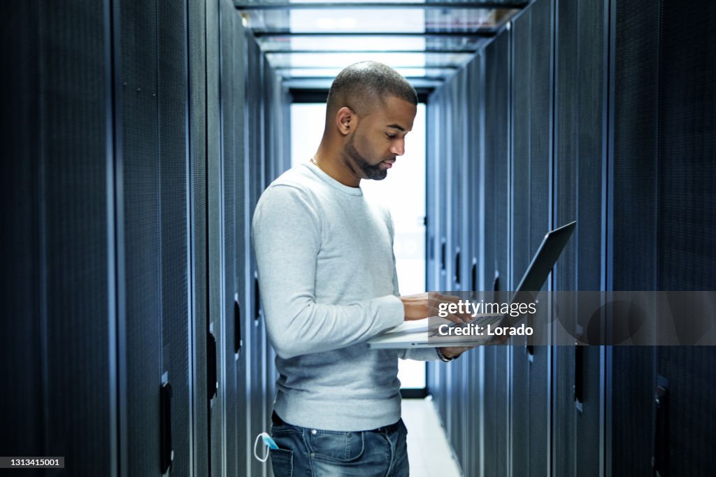 A black male server room technician working at business reopening