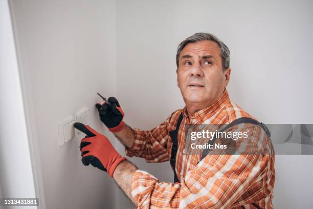 an electrician repairs a home installation - plaid shirt stock pictures, royalty-free photos & images