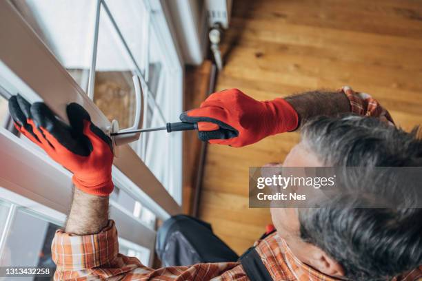 a worker installs windows - replacement windows stock pictures, royalty-free photos & images