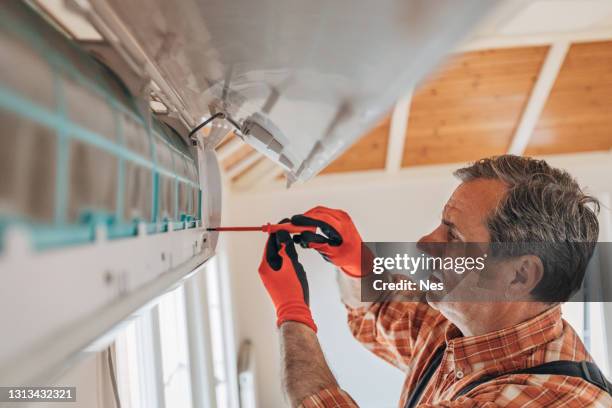the technician installs the air conditioner - air conditioner installation stock pictures, royalty-free photos & images