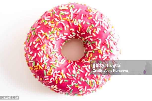 pink donut with colourful sprinkles isolated on white background - biting donut stock pictures, royalty-free photos & images