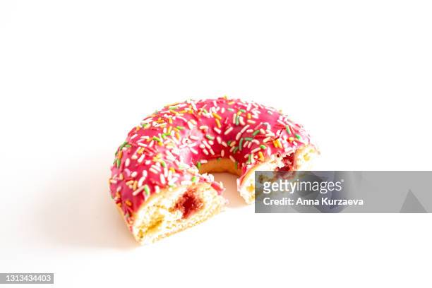 pink donut with colourful sprinkles isolated on white background - center back stock-fotos und bilder