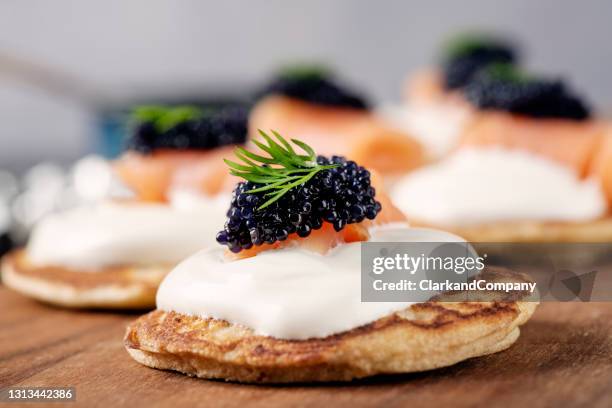 hausgemachte blinis mit creme fraiche, räucherlachs und kaviar - kaviar stock-fotos und bilder