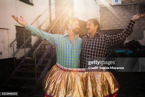 a lgbt couple trying on items inside their fancy dress shop - 2021 a funny thing stock pictures, royalty-free photos & images