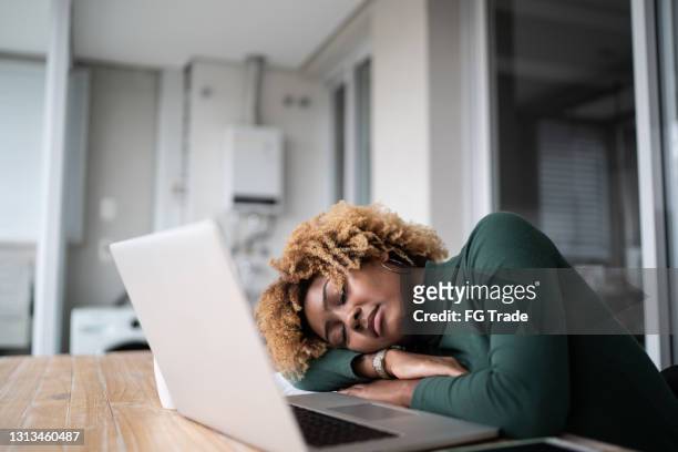 Young woman taking a nap while working or studying at home
