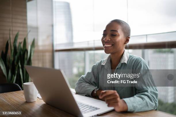 jonge vrouw die en een virtuele bedrijfsvergadering op laptop thuis werkt doet - jobs film stockfoto's en -beelden