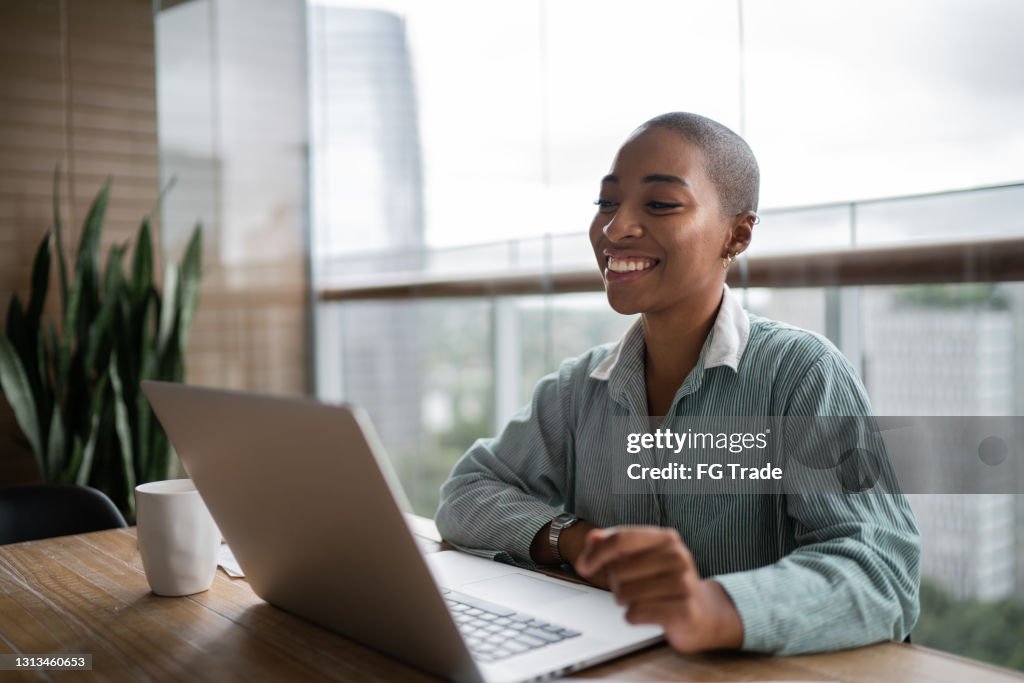 Young woman working and doing a virtual business meeting on laptop at home