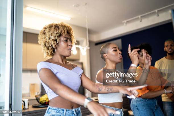 friends together dancing in front of television at home - virtual concert stock pictures, royalty-free photos & images