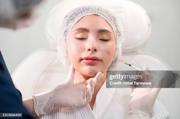 beautiful woman getting a botox injection on her face by a nurse in a beauty clinic. skin care clinic business. - asian woman beauty shot photos et images de collection