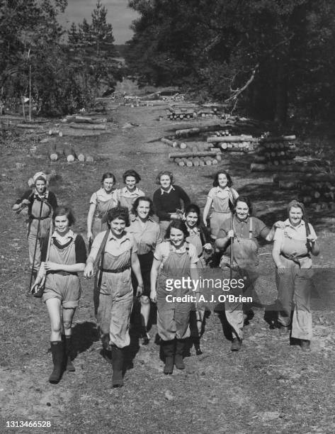Members of the Women's Land Army march back following a training course in felling and sawing trees and logs on 2nd September 1940 at Bury St....