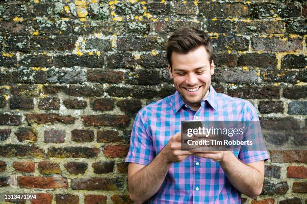 man using smart phone and laughing - blank shirt stock pictures, royalty-free photos & images