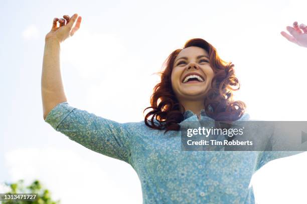 woman jumping in air, laughing - faces smile celebrate stock pictures, royalty-free photos & images